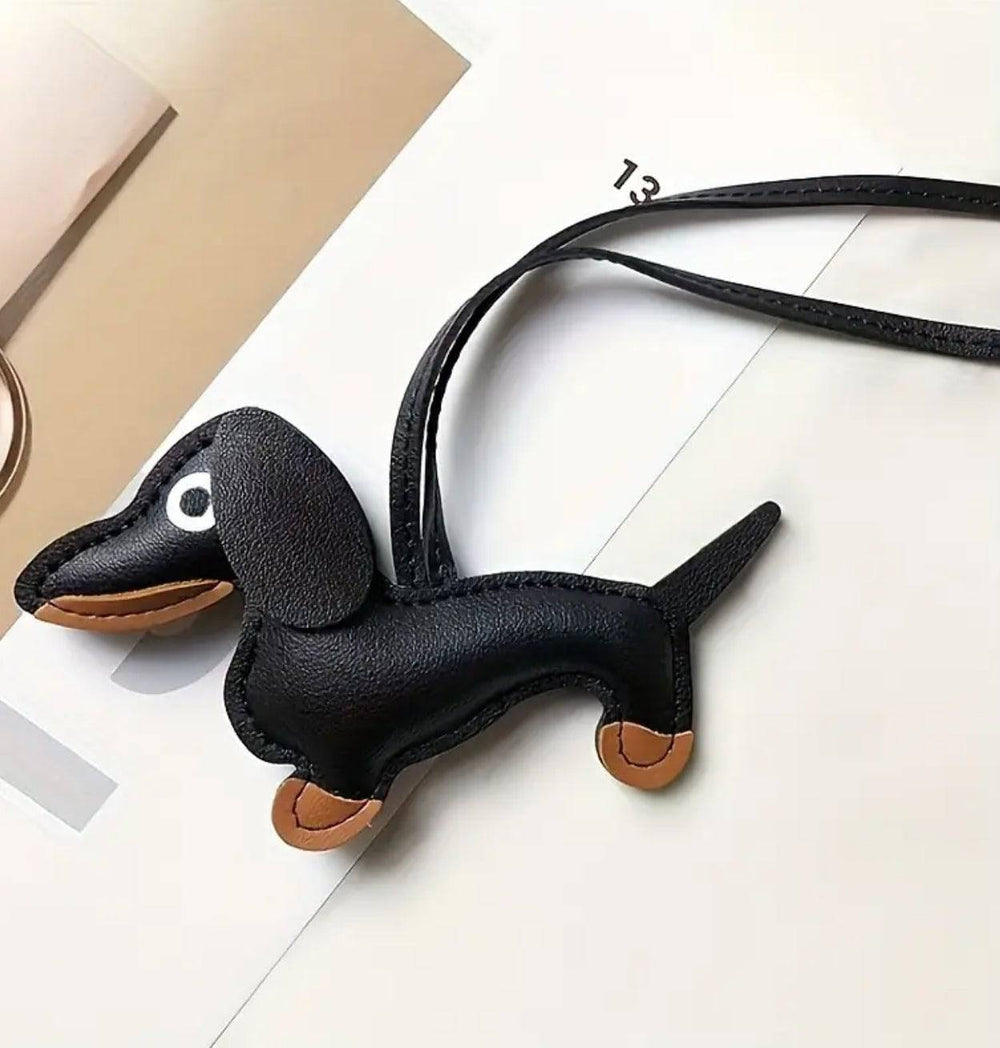 Emma & Rose Cape Town Charlize Dachshund-shaped bag charm hanging from a purse, showcasing its adorable dog design.