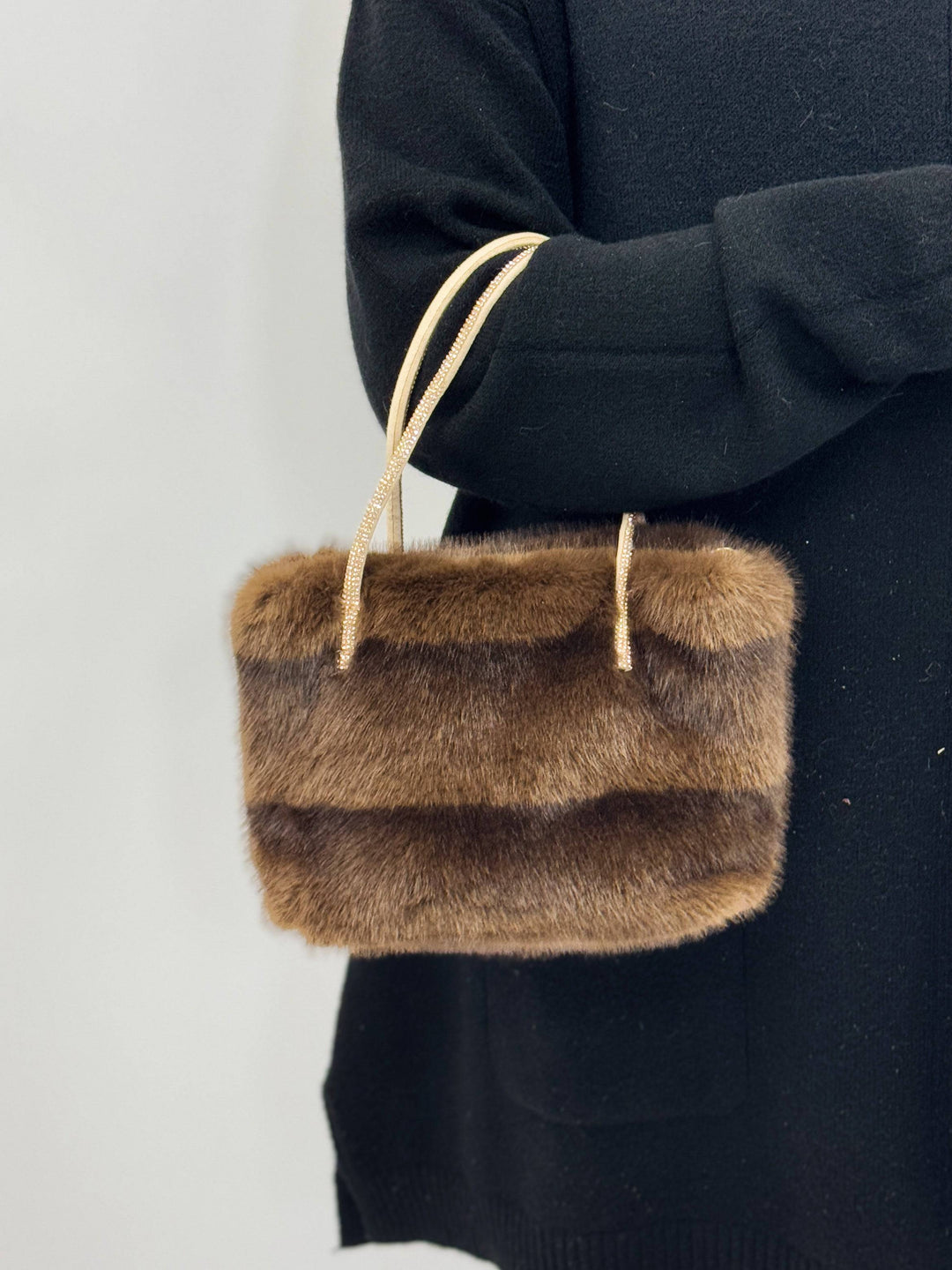Faux™ fur bag with decorative handles by Emma & Rose Cape Town, stylish black borse featuring plush fur accents and elegant design.